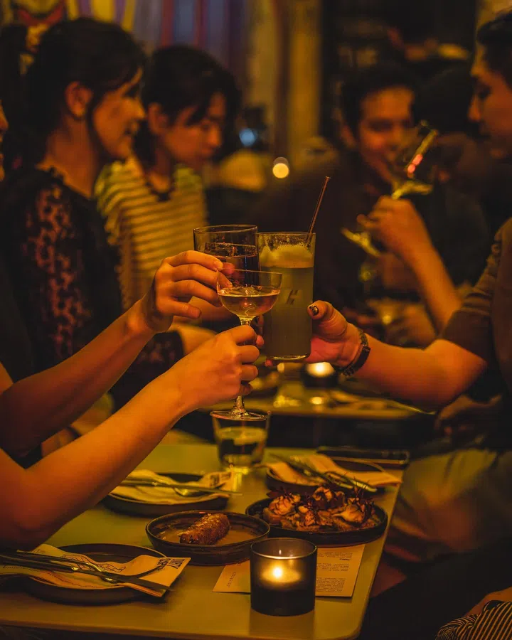Diners enjoying drinks and food at Dirty Supper/Dirty Sips