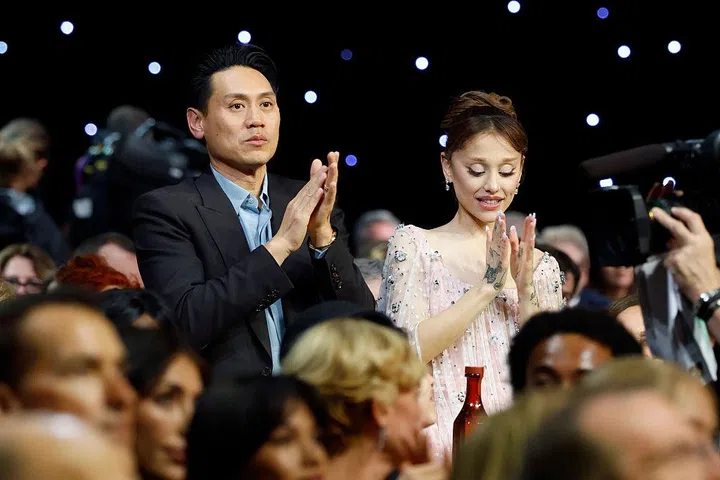 SANTA MONICA, CALIFORNIA - JANUARY 04: (L-R) Jon M. Chu and Ariana Grande applaud as B"KPop Demon Hunters" wins Best Song Award for 'Golden' the 31st Annual Critics Choice Awards at Barker Hangar on January 04, 2026 in Santa Monica, California. (Photo by Kevin Mazur/Getty Images for Critics Choice Association)