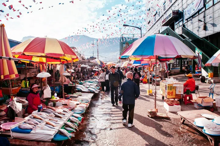 Various fresh fishes shops and colourful umbrellas at Jagalchi seafood market, famous tourist attraction in the morning