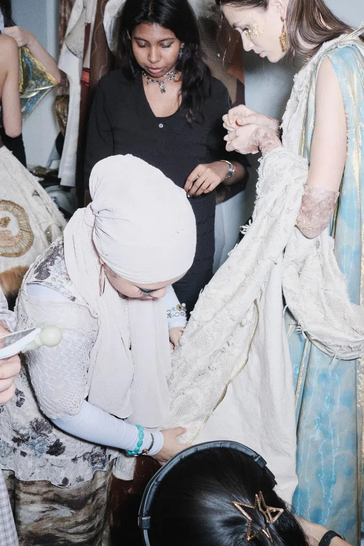 Designer checking on model backstage