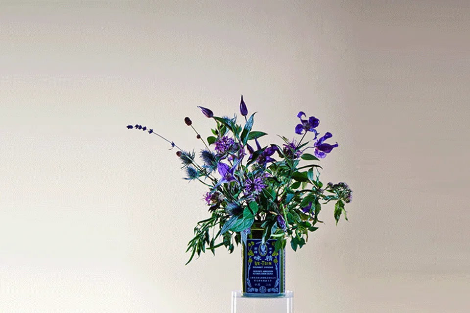 One man's discarded tin can... Puline Ho's flower vase.