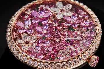A watch from Dior mimicking a lush garden, featuring a rose gold dial set with diamonds, pink sapphires, rubies and tsavorite garnets.