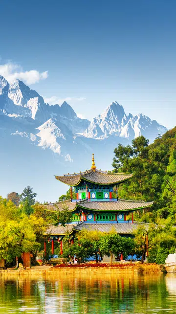 Scenic view of the Jade Dragon Snow Mountain and the Moon Embracing Pavilion on the Black Dragon Pool in the Jade Spring Park, Lijiang, Yunnan province, China.