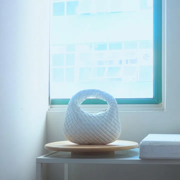 Bottega Veneta white Intrecciato Baby Veneta bag on a wooden pedestal in Hilary Yeo’s sculpture studio for F ZINE.