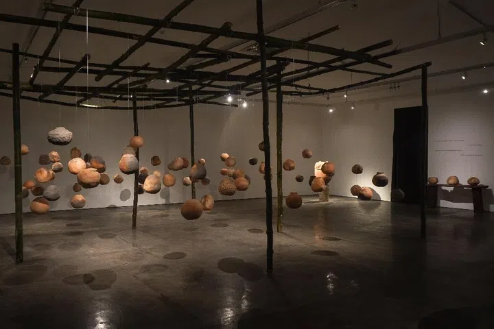 an exhibition with hanging wooden orbs, at ART SG fair 2026