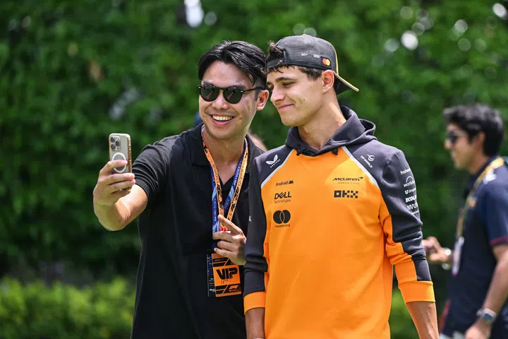 SINGAPORE, SINGAPORE - OCTOBER 05: Lando Norris of Great Britain and McLaren takes a selfie with a fan prior to the F1 Grand Prix of Singapore at Marina Bay Street Circuit on October 05, 2025 in Singapore, Singapore. (Photo by Simon Galloway/LAT Images)