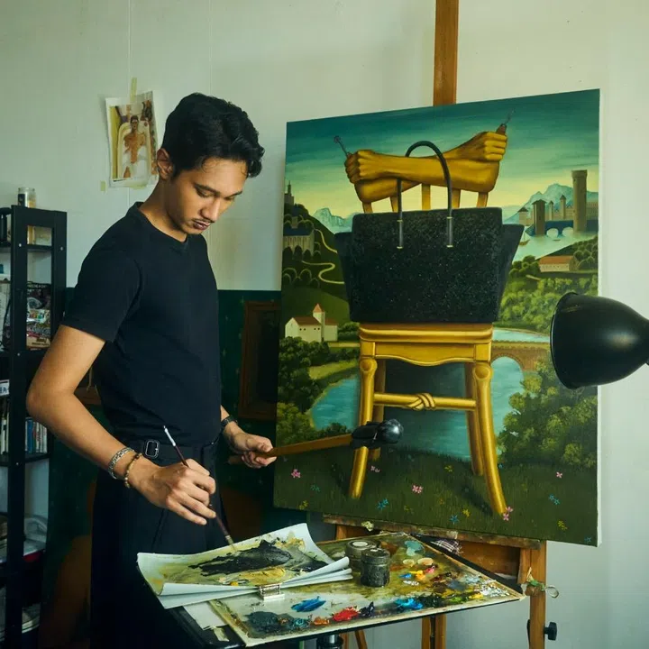 Artist Israfil Ridhwan painting a surrealist landscape inspired by the Bottega Veneta Barbara tote bag for F ZINE.
