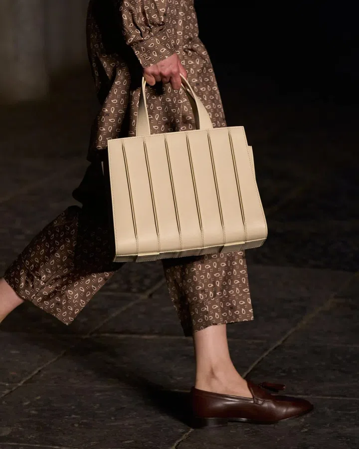 The Whitney Bag returns with fresh structure and quiet polish, paired with slinky pyjama trousers that blur the line between loungewear and luxury. Credit: Max Mara
