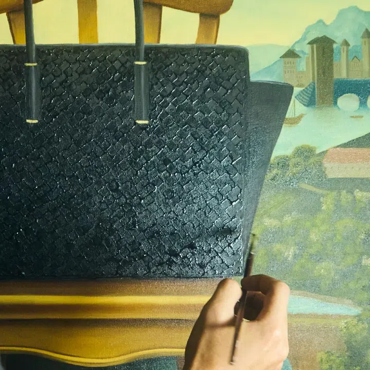 Close-up of Israfil Ridhwan painting the Bottega Veneta Intrecciato leather texture on a surrealist oil canvas.