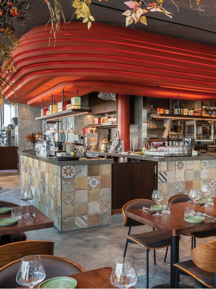 Interior of Alice Boulangerie café at Raffles City Singapore with rustic wood furniture, tiled counter and preserved blooms