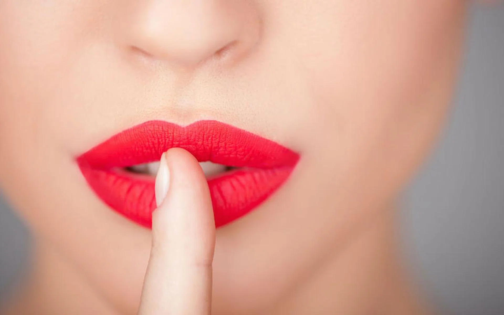 43354700 - hush-hush. close up of female red lips. the woman is raising her finger to mouth
