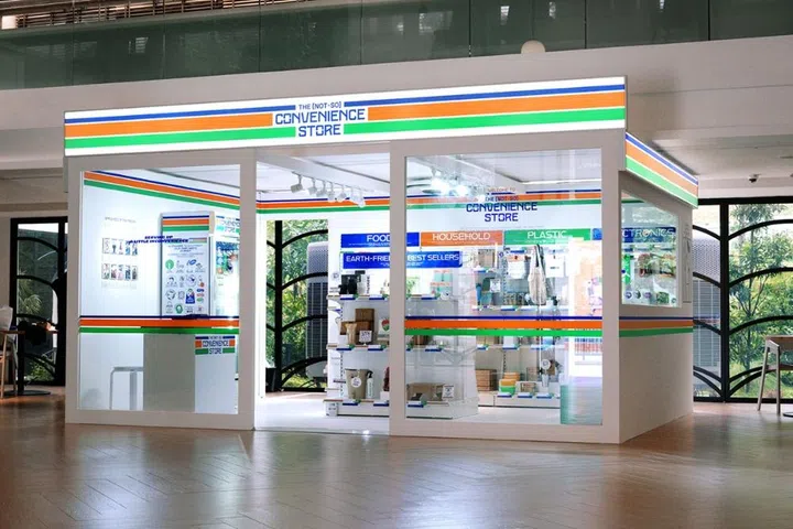 An installation view of “The (Not-So) Convenience Store” by Kinetic Singapore, a sustainable design project featuring eco-friendly household goods in a minimalist glass-walled booth.