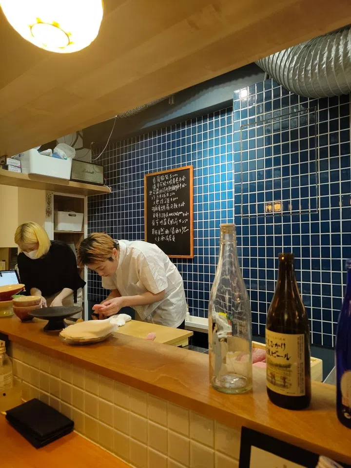 Minimalist retro interior of Peacewave Izakaya (和平波浪) in Taipei, showcasing ambient red floor lighting, wooden architectural details, and a cozy dining atmosphere.