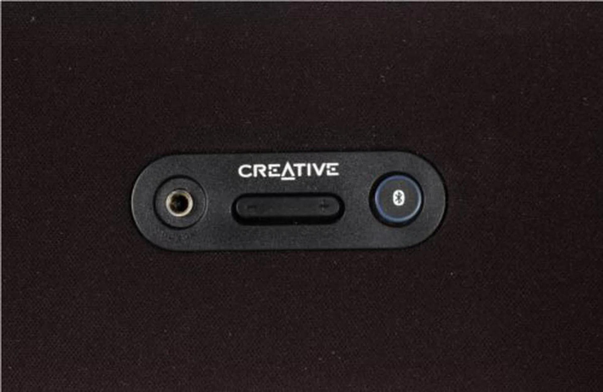 Smack in the center of the fabric grille are (from left) the Aux-in jack, the volume controls, and the Connect button/LED indicator.
