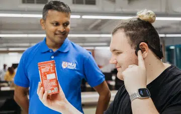  Associate Professor Suranga Nanayakkara (left) with NUS student Mark Myres (right), who tested AiSee as a visually impaired user.
Image source: National University of Singapore