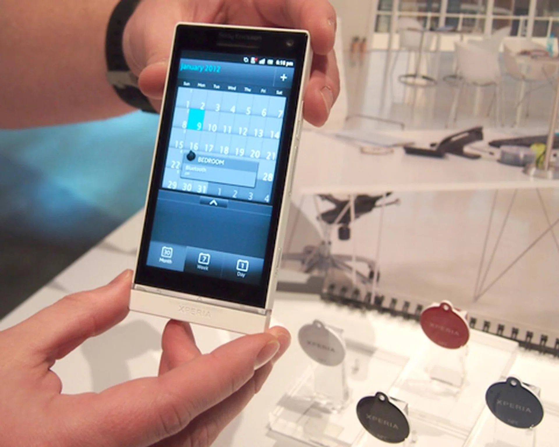 The SmartTags (pictured in the background) holds specific configurations within the NFC tags, which switches the Xperia S to the pre-configured setting once it's tapped with the SmartTag.
