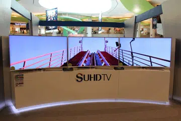 Three Samsung 65-inch JS9500 4K SUHD curved smart TVs side by side.
