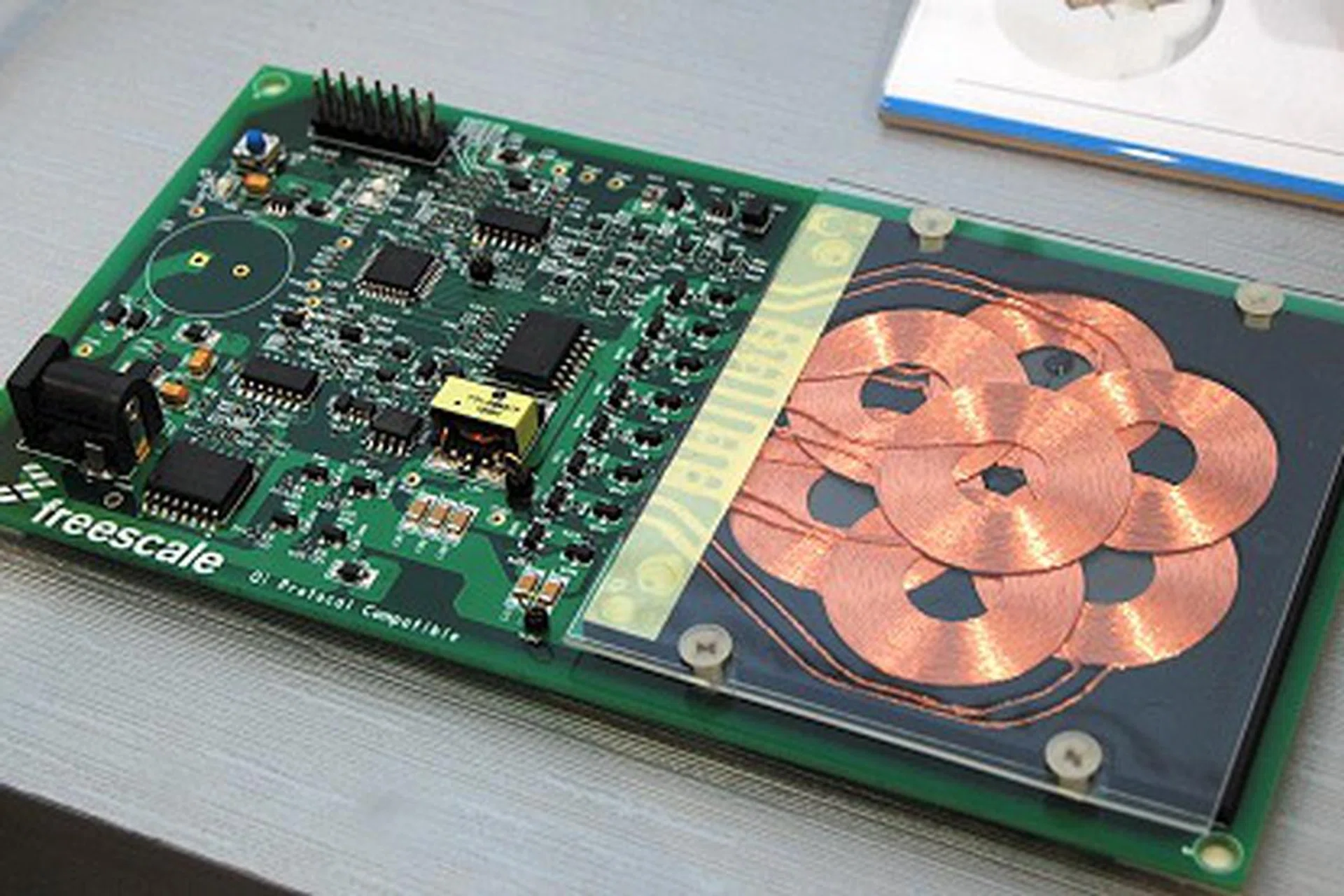 Shown in here in their booth is a wireless charging transmitter pad reference design aimed at mobile phones. The multi-coil array design in the transmitter unit allows for more care-free positioning of the mobile device (receiving unit) where only selective coils are activated for charging.