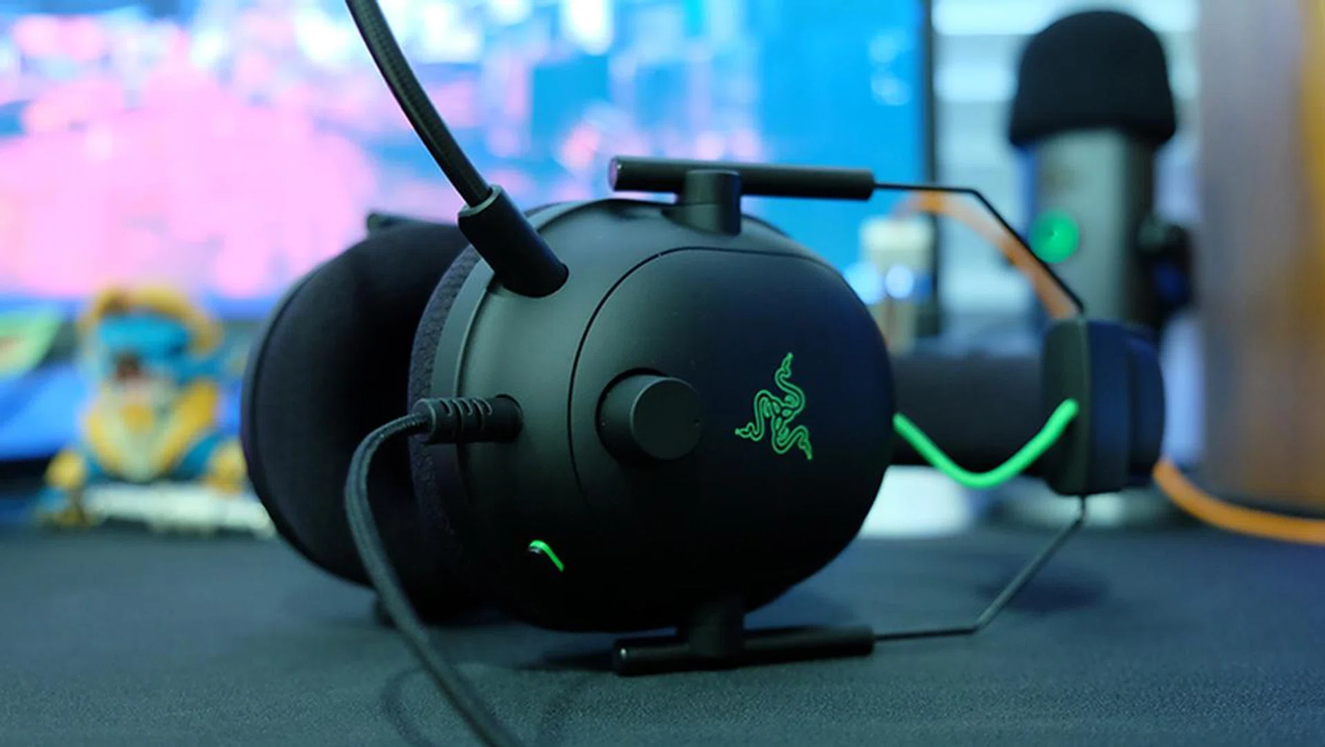 The volume knob and microphone mute button sit on the left ear cup. 
