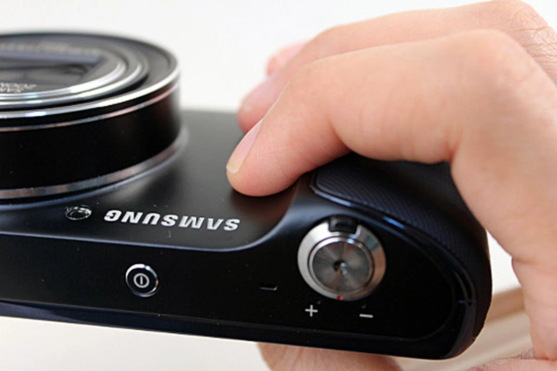 The textured surface of the hand grip ends before where the average person will hold the camera, so your fingers are actually on the smooth part of the body. 