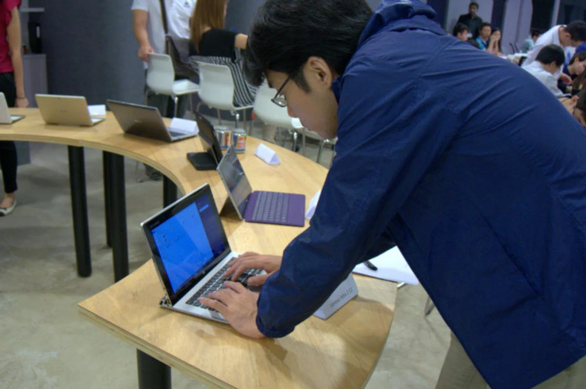 An attendee taking a closer look, literally, at the Lenovo Miix 2 11, one of the Windows hybrid notebooks on display.