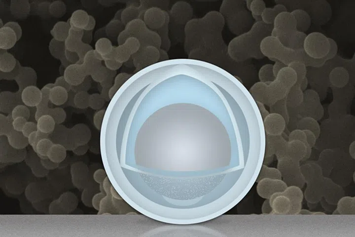 (Foreground): A pictorial representation of the egg and yolk nanoparticle structure; the grey center is the "yolk", and the outer most layer is the shell of the "egg". (Background): An actual electron microscope image of a collection of yolk-egg nanoparticles. (Image source: MIT)