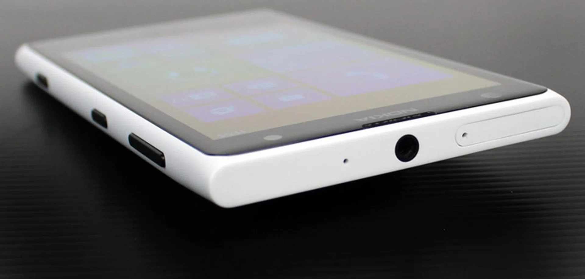 On top, you'll find the headphone port and Micro-SIM tray. Like previous Lumia phones, there's no Micro-SD card slot, which is a pity considering the phone's imaging capabilities and the fact that the 808 Pureview did include one. As you can see, the 1020's rather large camera bump doesn't let the phone lie flat on its back.