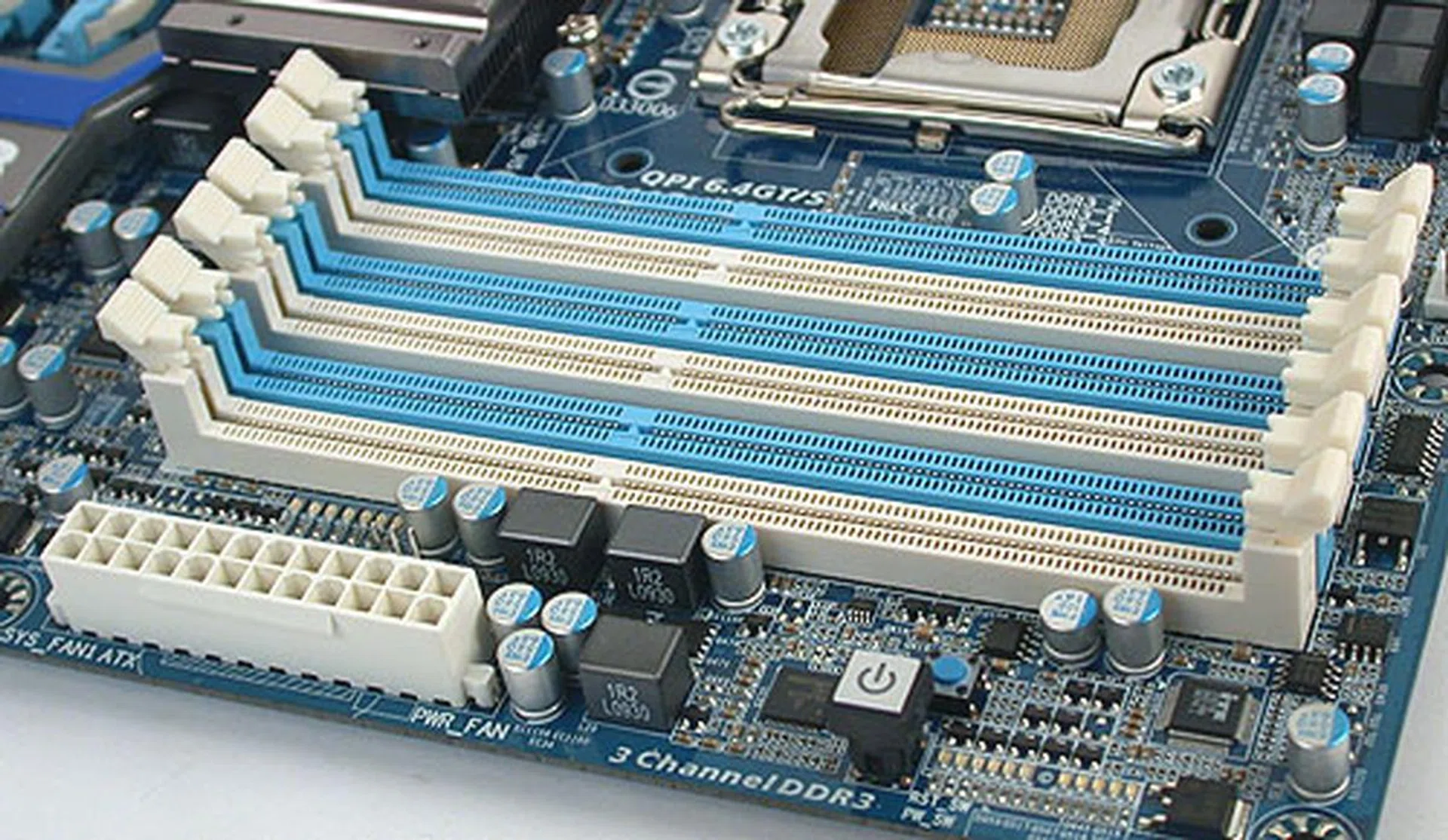 The triple-channel DIMMs and the power button. Right next to the power button is the much smaller, blue reset switch.