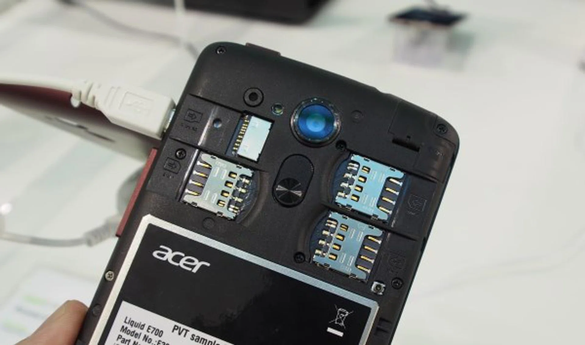 Removing the cover reveals three SIM slots and a microSD slot. However, the battery is built-in and cannot be removed.