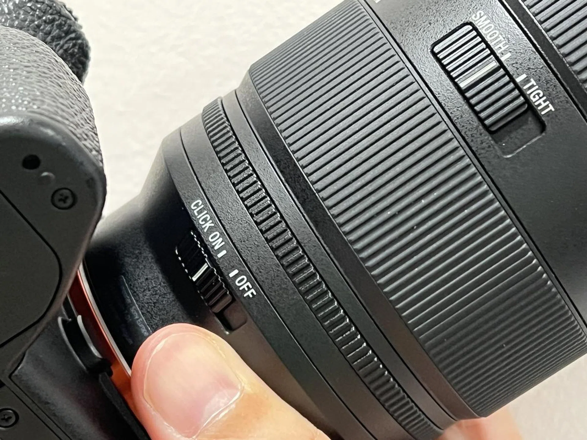 You will find the aperture click switch and zoom smoothness switch near the bottom of the lens when mounted.