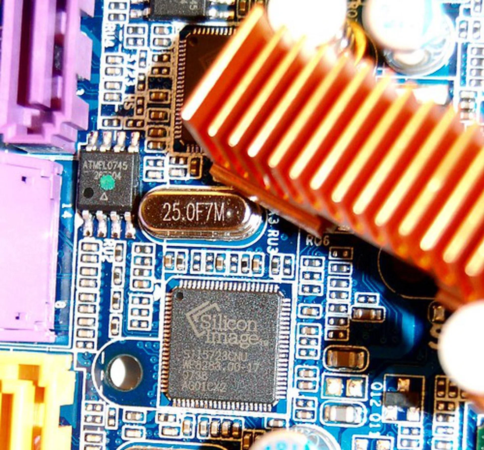 Removing another heatsink below the JMB363, we find a pair of Silicon Image SiI5723 SteelVine hardware RAID processors. These give rise to the four extra SATA 3Gbps ports in addition to those from the ICH10R chip.