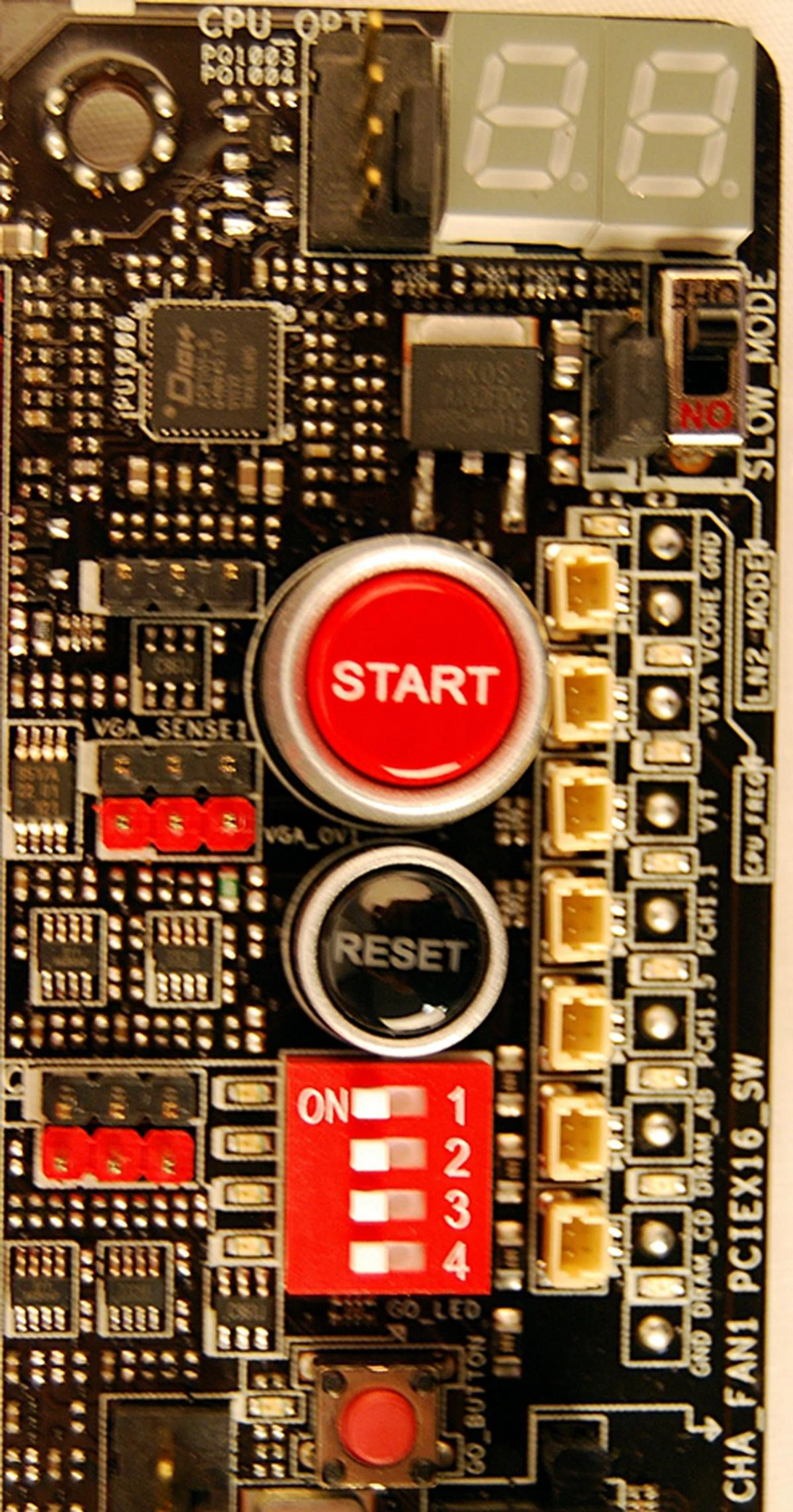 In the top right hand corner below the Debug LEDs, the Slow Mode switch is employed during LN2 benching. Flipping it will 'slow' the CPU to prevent the system from crashing when attempting to boot into the OS at cold temperatures. The red 'GO' button enables ASUS' MemOK! feature to fix memory incompatiability issues before booting into the OS.