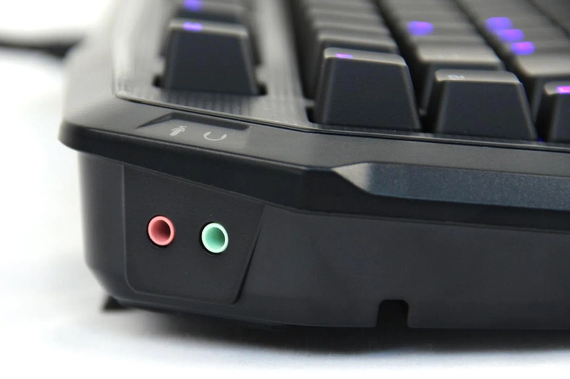 On the back left corner of the MK Pro, you'll find microphone and headphone pass-through ports. To use the ports, you'll have to connect the matching cables to the back of your computer.