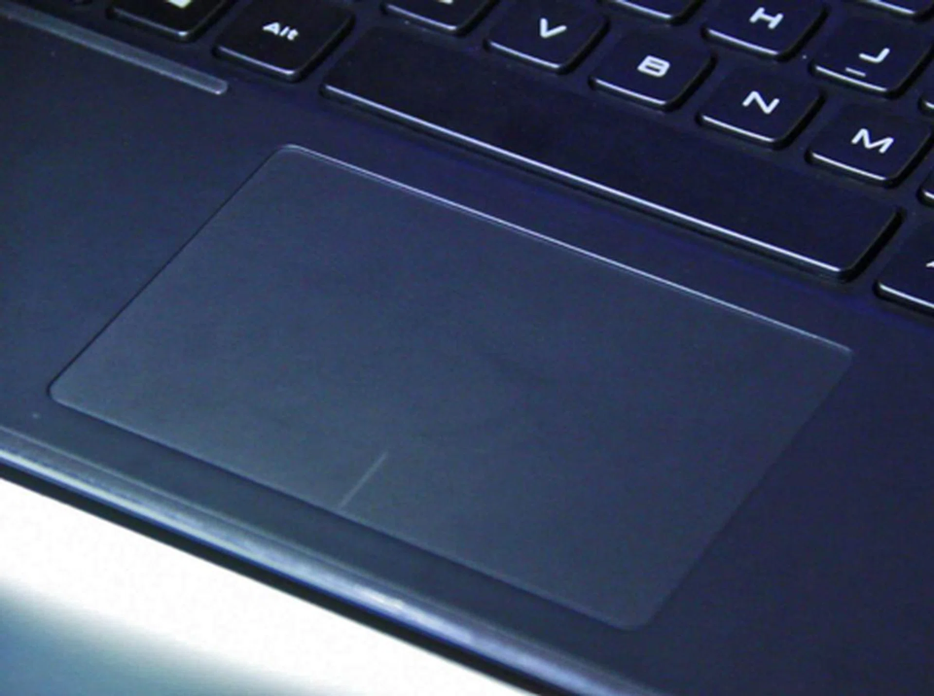 The glass trackpad is coated with a teflon like material. You can't fry an egg on it, but it does allow your finger to slide around very easily. 