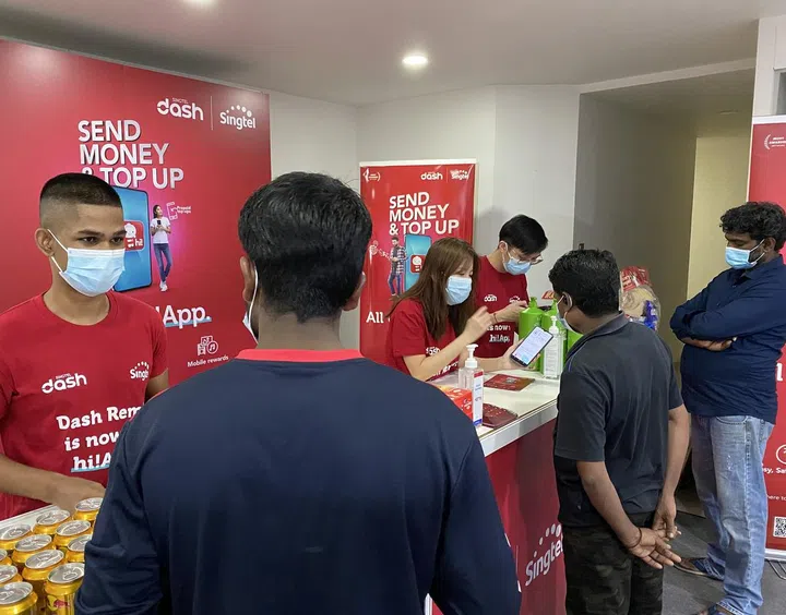 Singtel volunteers helped residents set up Dash Remit on hi!App during the Deepavali event held at a dormitory on 7 November. Credit: Singtel.