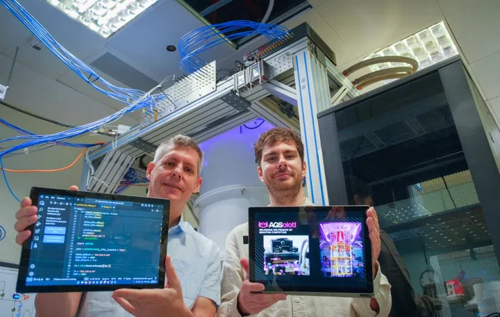NTU Assoc Prof Rainer Dumke (left) with AQSolotl CEO Patrick Bore (right), with their Chronos-Q quantum controller (in black) seen in the top right corner of the quantum computer at NTU. Photo: NTU. 