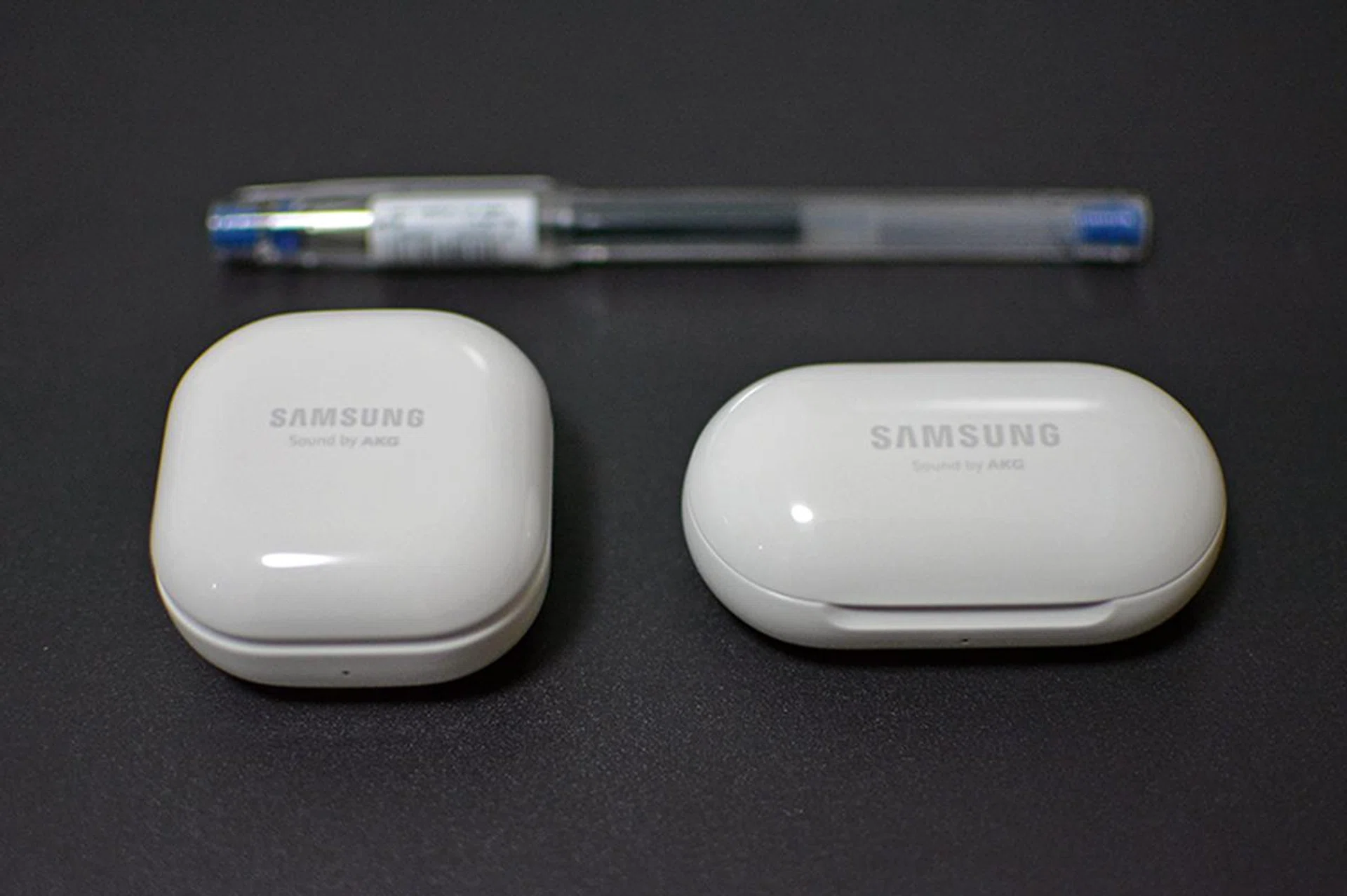 The Galaxy Buds Live and Buds+ side by side, with a pen for scale.
