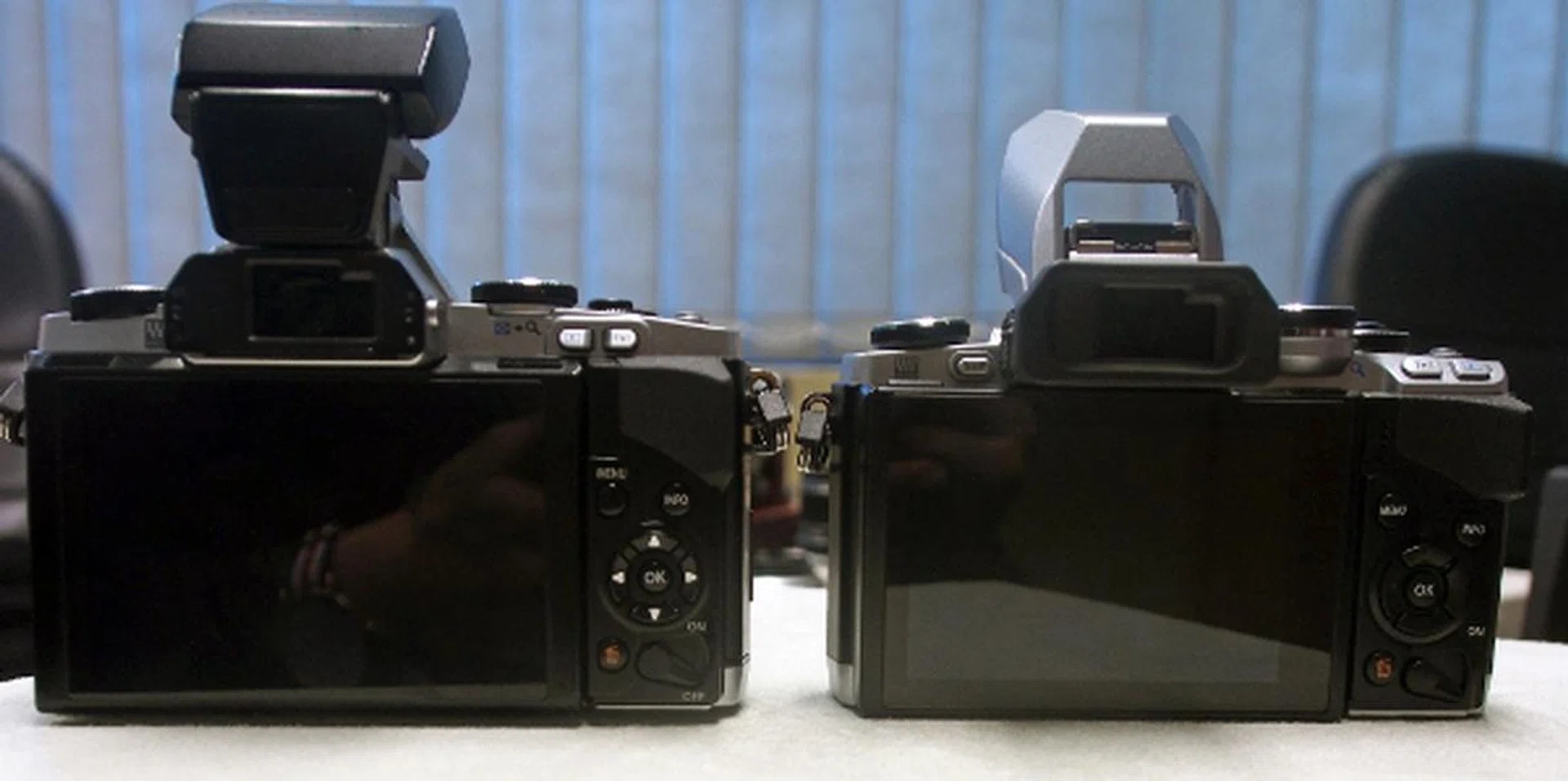 The button placement and button sizes on the rear of the E-M10 (right) are very similar to the E-M5, with the exception of the Playback button and Function button, which have swapped places but are still located at the top right.