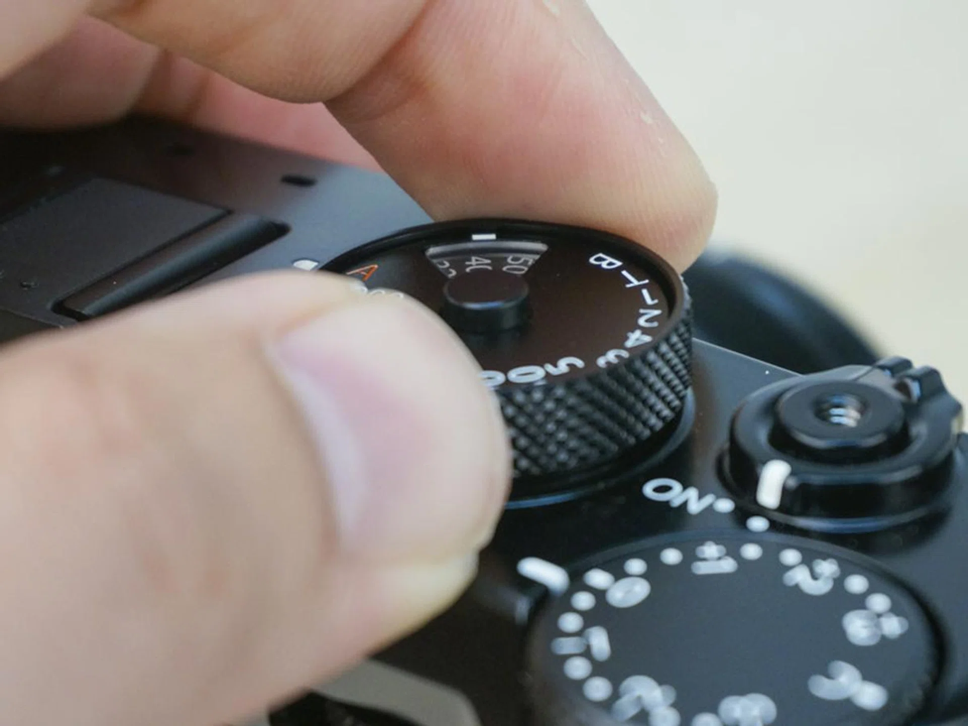 To adjust ISO, lift the sides of the shutter dial up and turn. 