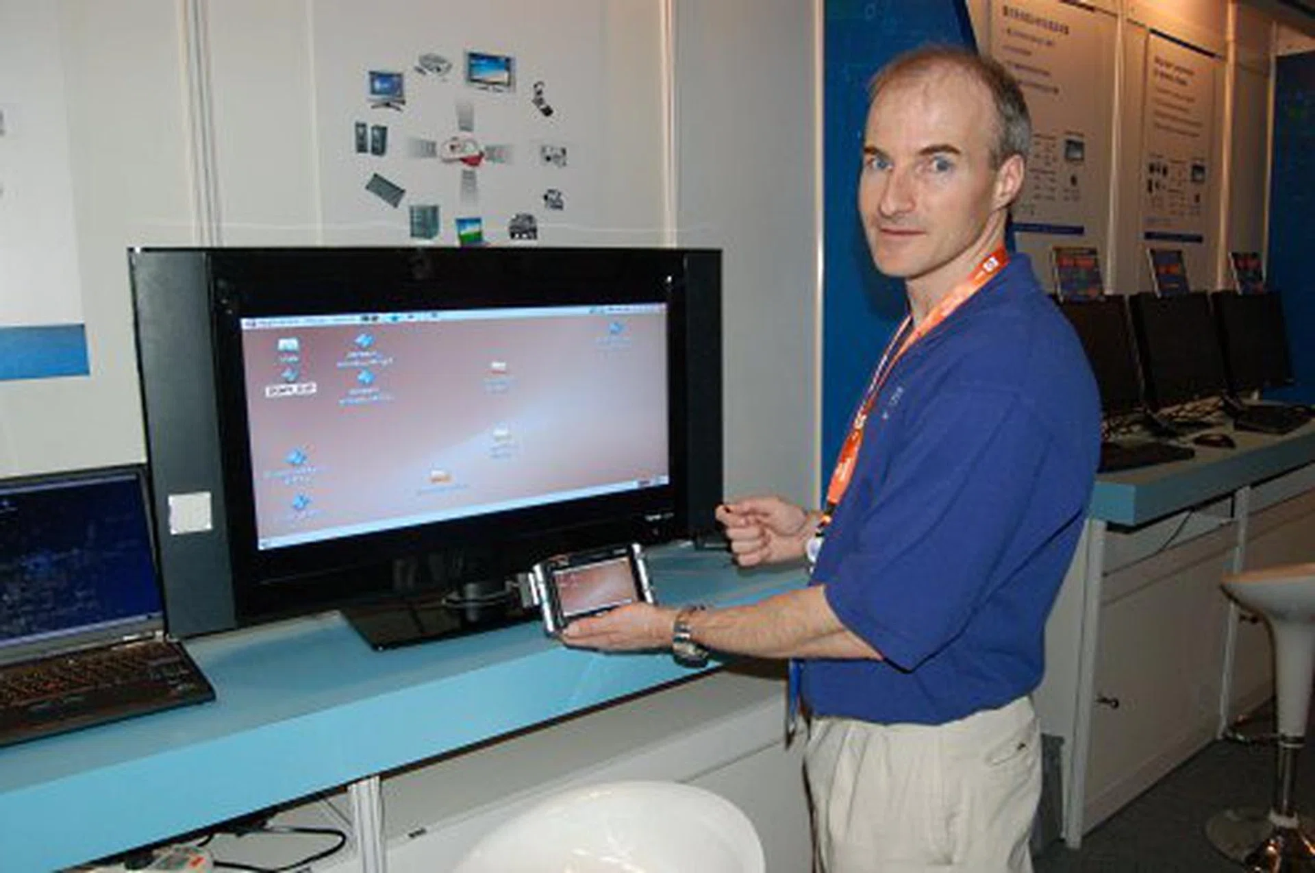 Wireless device discovery and setup demo where the mobile device will scan the room for WiFi enabled deviced with a monitor that it can latch on to. After secure connection via pin input or near field link-up, the mobile device can either take control of the linked display as its own, or stream video, data, etc. One caveat, the WiFi devices must be tailored to include certain information in its broadcast so the mobile device can identify them. While the technology works, Intel must first secure a standards body to make the broadcast information an industry standard for it to go anywhere.