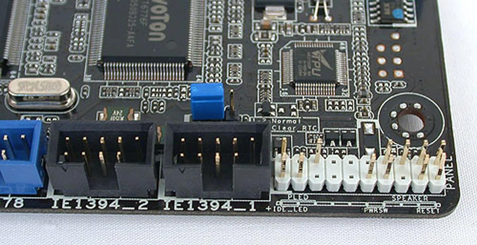 At the other corner of the board, we see the BIOS reset jumper in blue along with the front panel connectors. The FireWire headers are also located here. 