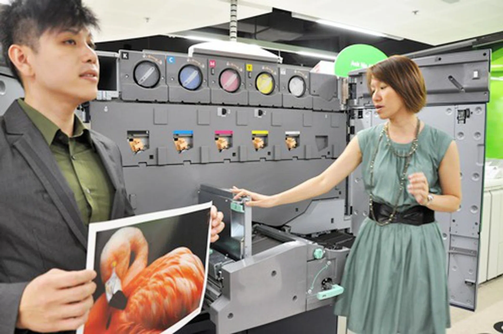Fuji Xerox staff showing the media print samples as well as explaining the mechanics behind the Fuji Xerox Color 1000. At the extreme top right of the machine, the clear dry ink station can be seen.