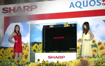 Two babes flank the 3D AQUOS Quattron during its unveiling ceremony. In a nutshell, Sharp's Quattron technology was designed to render hues such as yellow, gold and emerald green in more vivid shades.