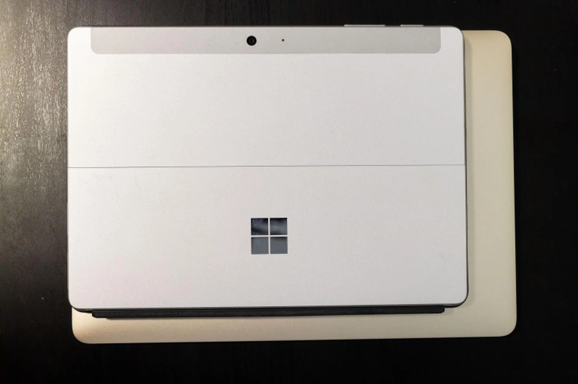 The Microsoft Surface Go juxtaposed against a 12-inch Apple MacBook. Yes, it's that small.