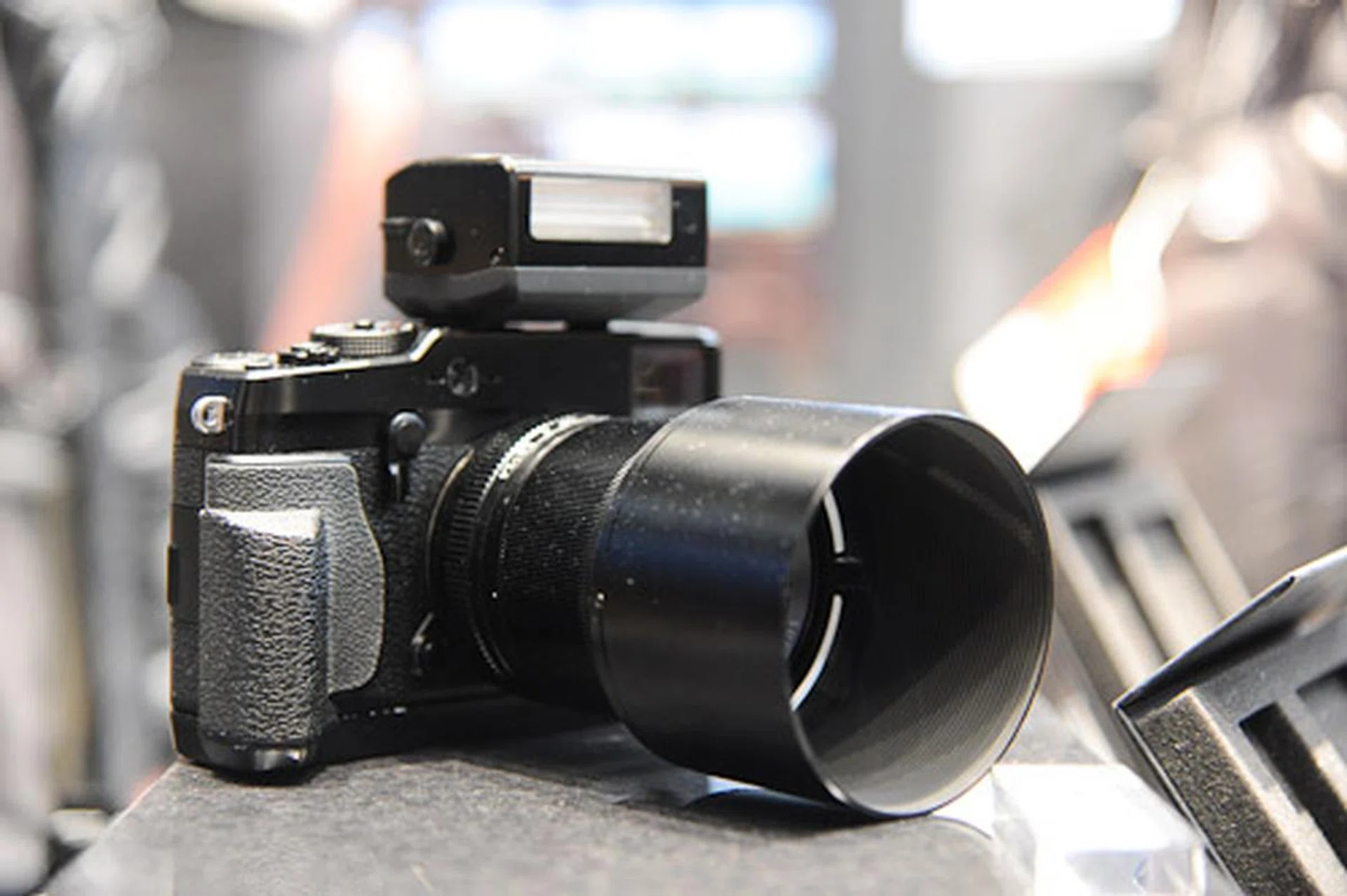 A tricked-out X-Pro 1 with flash attachment, additional hand-grip and lens hood.
