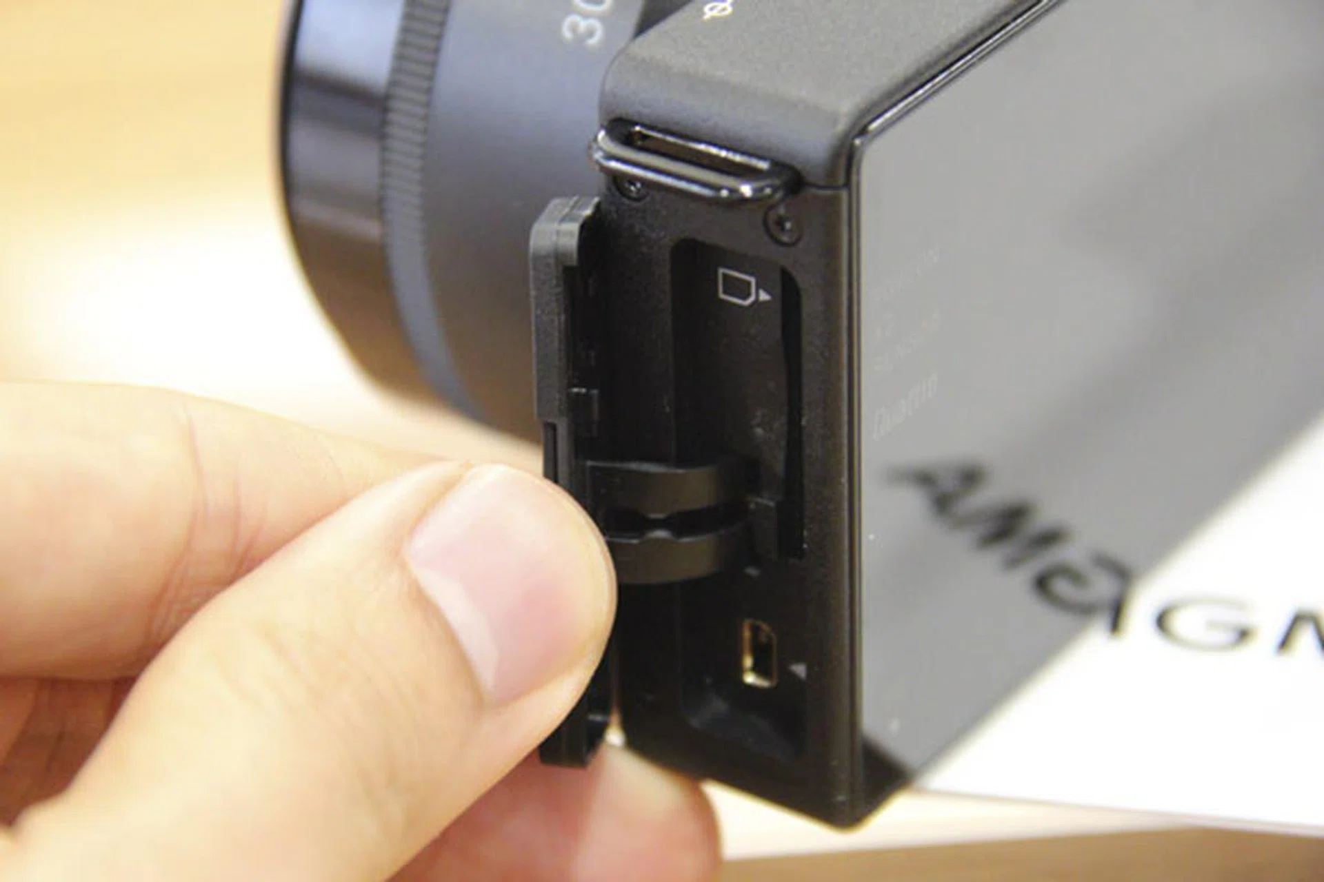 The SD card slot is on the left of the camera.