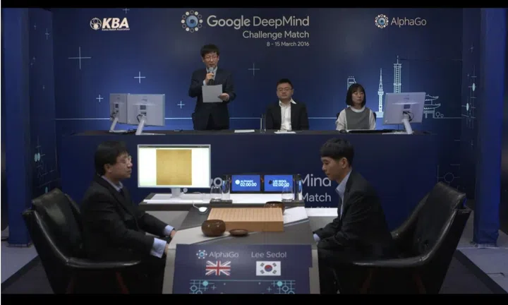 Moves by AlphaGo are represented on the chess board with the help of human proxies.