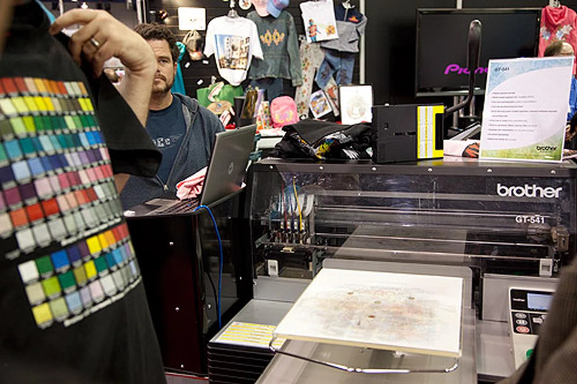 Brother's GT-541 digital garment printer is an inkjet printer that prints directly on t-shirts like a typical desktop inkjet printer. It can also print white on dark fabrics.