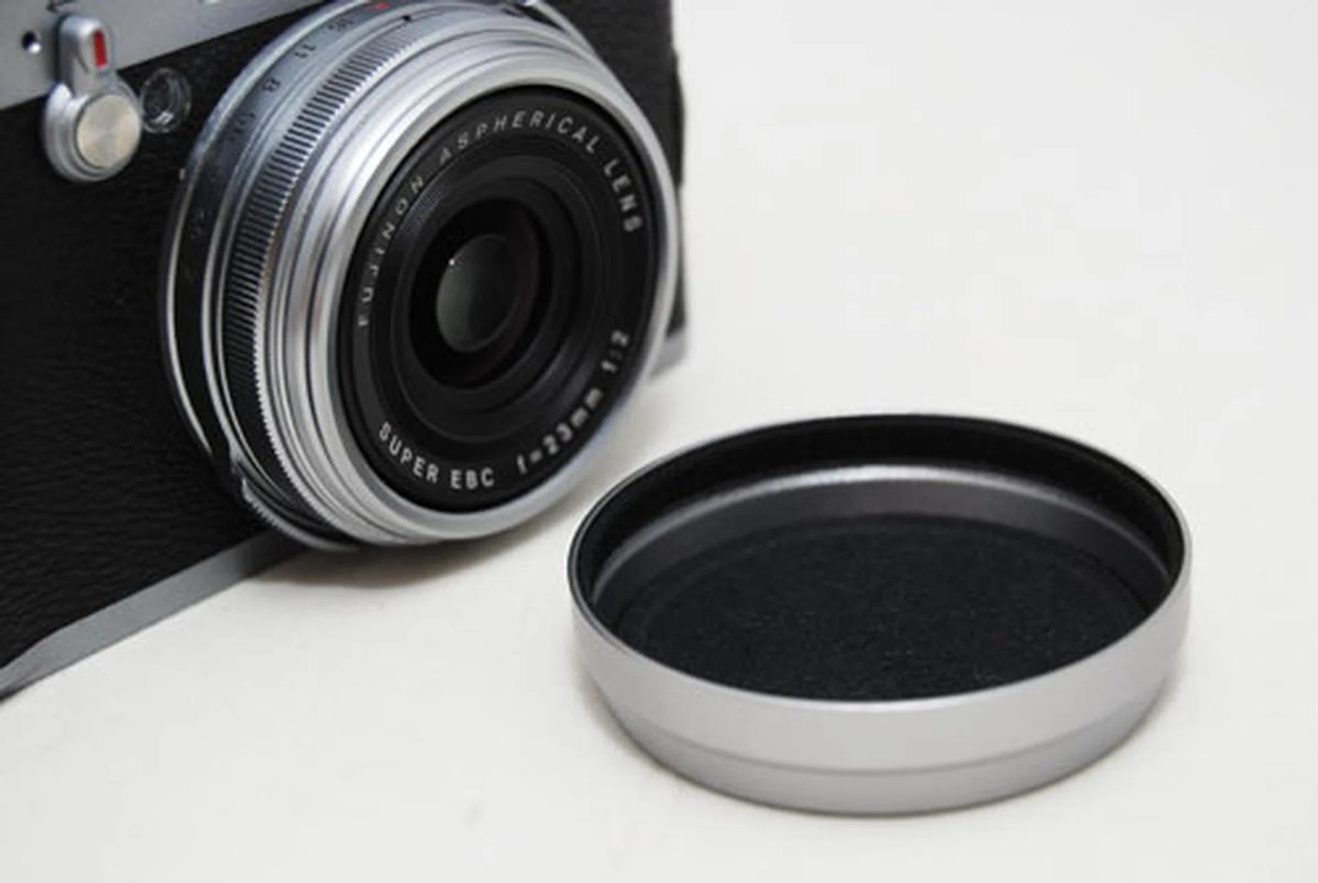 The aluminium lens cap is solid, but doesn't clasp onto the lens nor are there any straps to hang it off on.