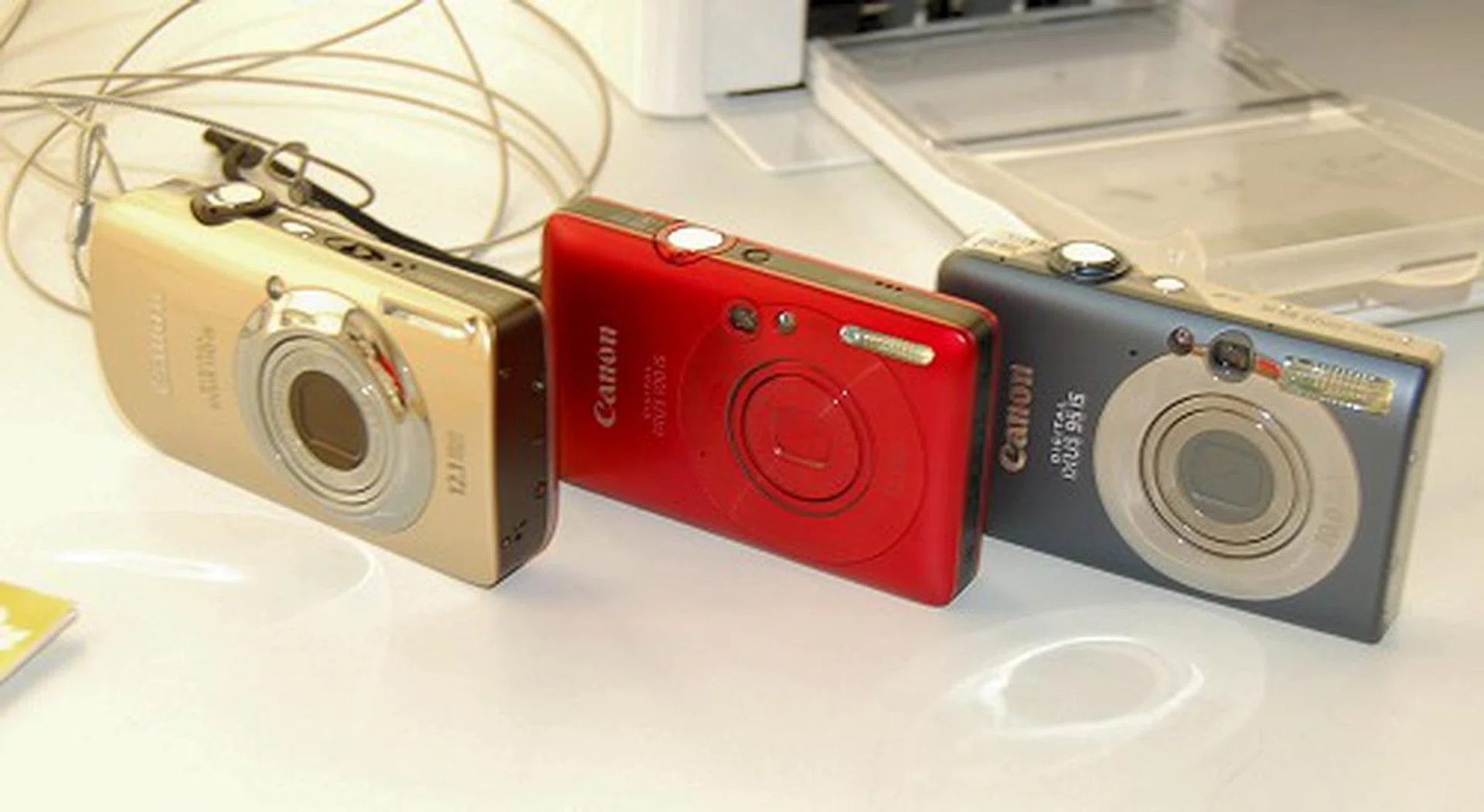  Here's a trio of fresh new IXUS cameras:- the 110 IS, 100 IS and 95 IS respectively from left to right. The IXUS 110 IS and 100 IS (gold and red), are both 12.1MP cameras, sport the new Canon DIGIC 4 processor and come with a new Smart Auto mode and HD (720p) movie recording options too. The IXUS 110 IS however is better suited for wide angle shots with its 28-112mm lens.  